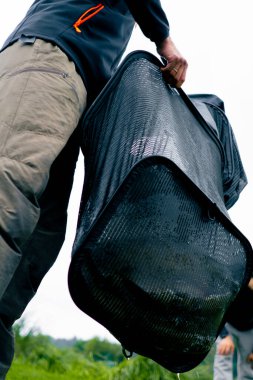 Nehirde balık yakalamak için profesyonel bir ağ tutan bir balıkçının yakın çekimi.