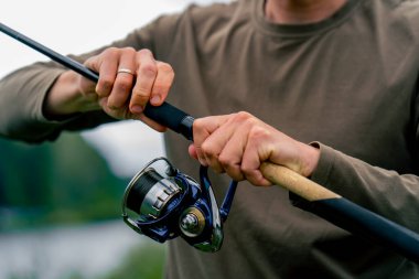 Yakın plan Fly balıkçı erkek eller olta ile elleri dönen elle besleyici serbest stil metodu