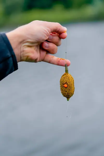 クローズアップ釣り食用餌 川の背景にフックに掛かる自然スポーツフィッシングフィーダーフリースタイル方法 — ストック写真