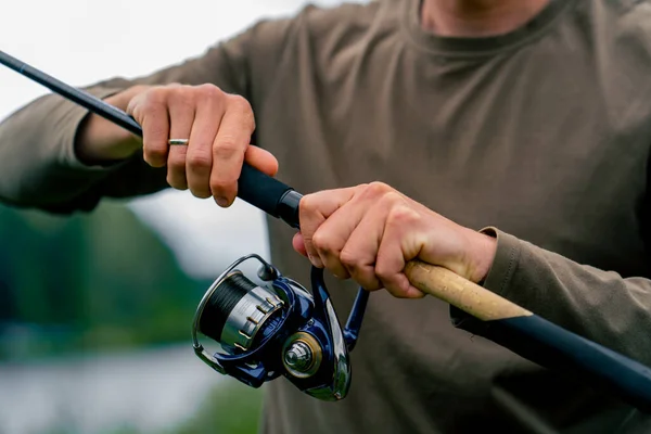 クローズアップ フライフィッシャーマン 手で回転釣り棒の男性の手 フリースタイル方法 — ストック写真
