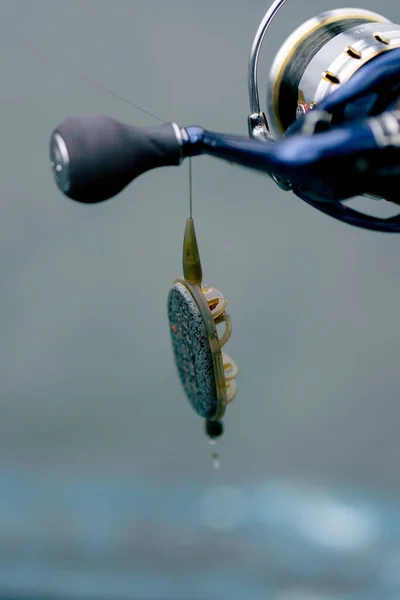 クローズアップフィッシングタックルスピニングホックと貯水池フィーダーフリースタイルの方法で漁師を保証 — ストック写真