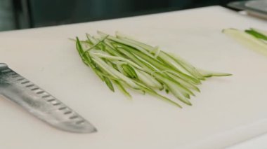 İnce dilimlenmiş taze salatalık. Restorandaki suşi için kurulun malzemesi.