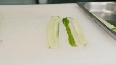 İnce dilimlenmiş taze salatalık. Restorandaki suşi için kurulun malzemesi.