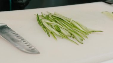 İnce dilimlenmiş taze salatalık. Restorandaki suşi için kurulun malzemesi.