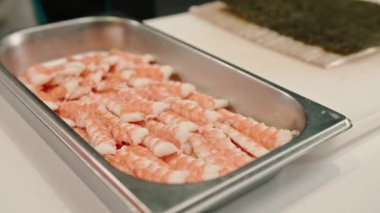 Profesyonel metal tepsilerin içinde suşi restoranının mutfağında karides bulunan suşi malzemelerinin yakın plan çekimi.