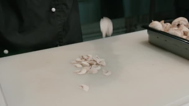 寿司を作っている間 プロのキッチンでホワイトボードにキノコを切る手袋の寿司メーカーのクローズアップ — ストック動画