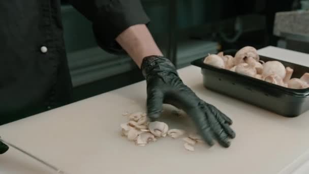 초밥을 만드는 부엌에서 보드에 버섯을 자르는 장갑에 메이커의 클로즈업 — 비디오