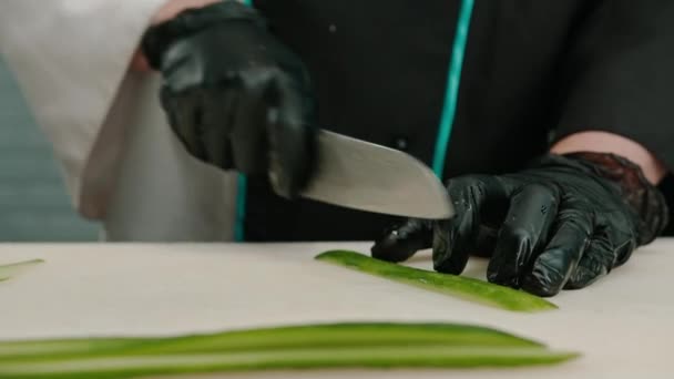 Primer Plano Fabricante Sushi Con Guantes Cortando Pepino Con Cuchillo — Vídeos de Stock