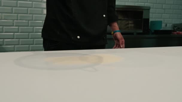 配達レストランで小麦粉でピザ生地を粉砕するための表面を粉砕するシェフのクローズアップ — ストック動画