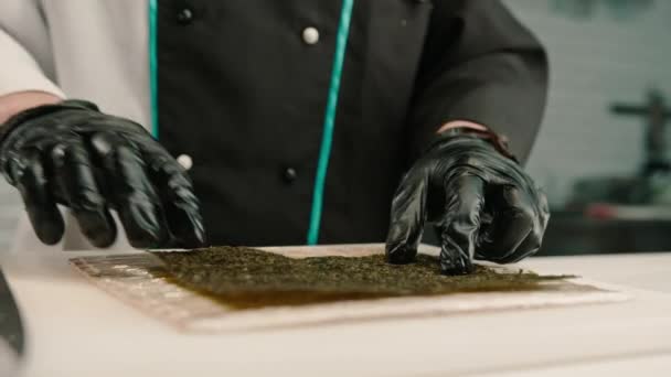 Close Chef Sushi Luvas Pretas Preparando Sushi Usando Folhas Arroz — Vídeo de Stock