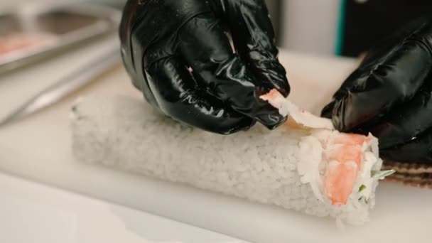 Zbliżenie Sushi Maker Czarnych Rękawiczkach Cięcia Filet Krewetki Nożem Podczas — Wideo stockowe