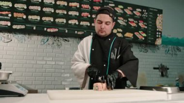 Suşi şefi fırında somon karidesi ve chuka yosun restoranının mutfağıyla lezzetli bir rulo kesiyor.