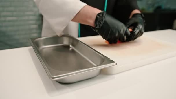 寿司屋のキッチンを調理しながら切削盤にサーモンフィレットを置く寿司シェフのクローズアップ — ストック動画
