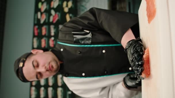 Wideo Pionowe Zbliżenie Kucharza Sushi Krojącego Filet Łososia Nożem Podczas — Wideo stockowe