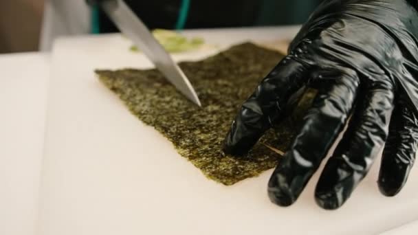 制作寿司时 在专业厨房的白板上用专业菜刀切割鳄梨手套的寿司制造商特写镜头 — 图库视频影像