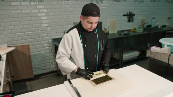 Close Van Sushi Maker Dragen Van Zwarte Handschoenen Verpakking Zalm — Stockvideo