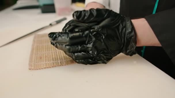 Close Van Sushi Maker Dragen Van Zwarte Handschoenen Verpakking Zalm — Stockvideo