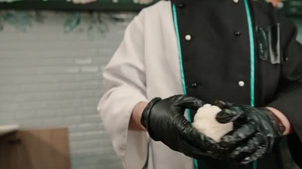 一名戴着黑色手套的寿司厨师在厨房桌上用米粉虾片虾仁凝乳芝士黄瓜鳄梨做寿司的特写镜头 — 图库视频影像
