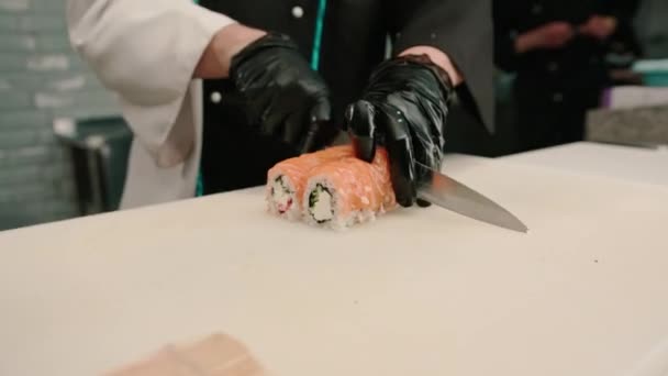Zbliżenie Sushi Szef Cięcia Świeże Rolki Łososia Nożem Japońska Restauracja — Wideo stockowe