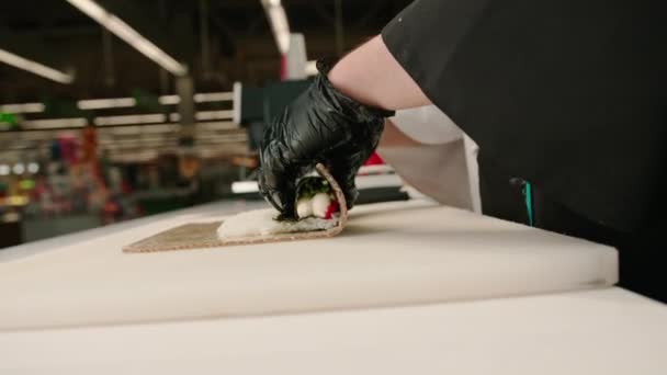 Zbliżenie Kucharza Sushi Zawijającego Filadelfijską Bułkę Łososia Używając Bambusowej Maty — Wideo stockowe