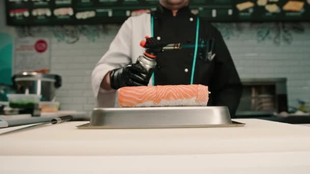 寿司大厨在寿司餐厅就餐前 应先用燃气炉将三文鱼卷放在手上 再放上特写 — 图库视频影像