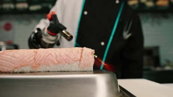 Zbliżenie Szefa Kuchni Sushi Palnikiem Gazowym Ręku Smażenie Bułek Łososiem — Wideo stockowe