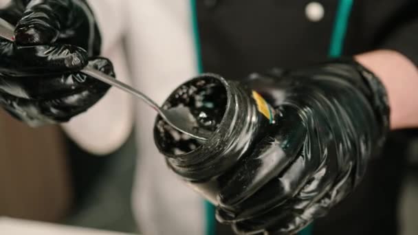 레스토랑에서 만들기 숟가락을 항아리에서 오징어 잉크를 당기는 요리사의 클로즈업 — 비디오