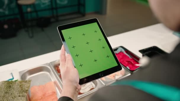 Zbliżenie Zza Kucharza Sushi Trzymającego Tabletkę Zielonym Ekranem Otwartym Podczas — Wideo stockowe