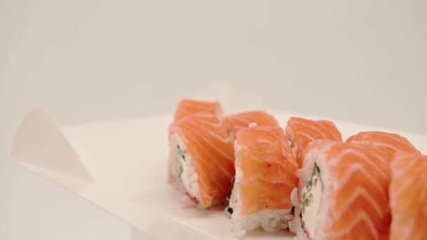 Närbild Philladelphiarulle Med Laxgurka Och Keso Vit Bakgrund Sushi Box — Stockvideo