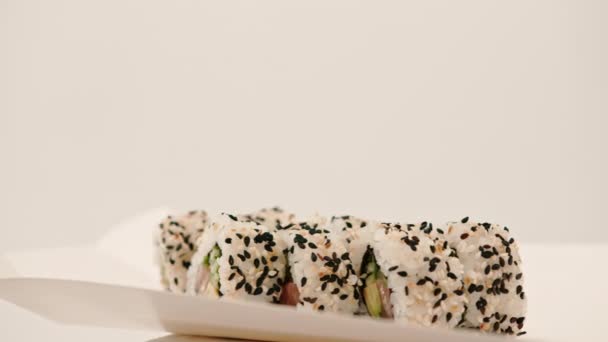 三文鱼卷的特写 里面有黄瓜 米和芝麻 背景为白色 — 图库视频影像