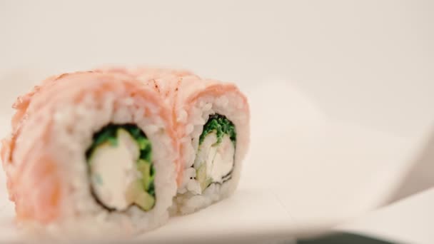 Detail Role Pečeným Lososem Okurkou Sýrem Bílém Pozadí Krabici Sushi — Stock video