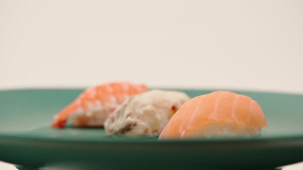 Närbild Tre Nigiri Sushi Med Lax Och Räkor Ligger Blå — Stockvideo