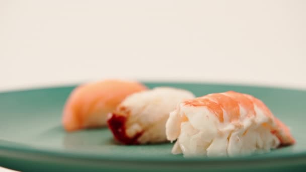 Zbliżenie Trzech Nigiri Sushi Łososiem Węgorza Krewetek Leżących Niebieskim Pięknym — Wideo stockowe