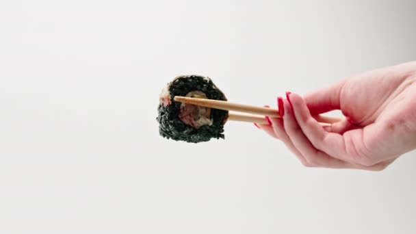 寿司与黑米和鳗鱼的特写镜头 男人拿着筷子 白色背景 — 图库视频影像