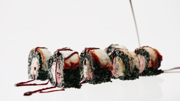 黒米ウナギのロールアップが美しいブループレートのアンギソースで乾燥 寿司とアジア料理のコンセプト愛 — ストック動画