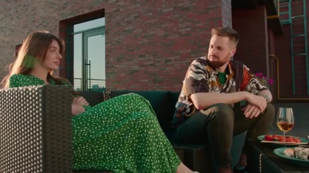 남성과 여성은 도시를 내려다 테라스에 앉아있는 데이트에 논쟁하고있다 — 비디오