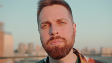 Genç sakallı, duygusal ve ciddi bir adamın kamera görüntüsü.