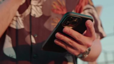 Kuryeyle haberleşme yoluyla akıllı telefon mesajlaşması yapan erkeklerin yakın çekimleri