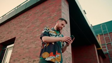 Bir adam elinde bir akıllı telefon ile çevrimiçi kurye ile mesajlaşıyor.