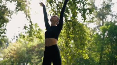 Spor kızı, antrenmandan önce kollarını omuz eklemlerini ısıtarak dairesel hareketler yapar.