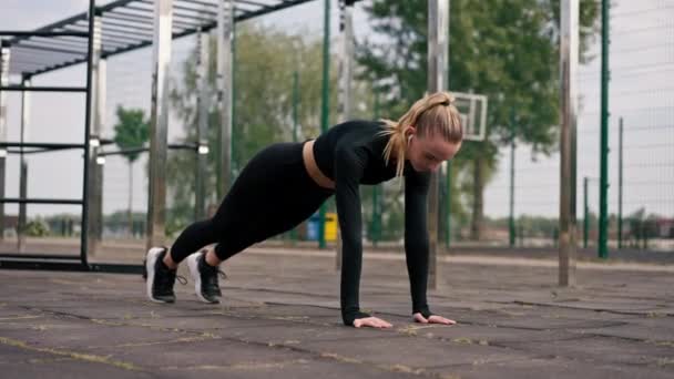 Een Sportplein Staat Een Opgepompt Meisje Plank Luistert Naar Motiverende — Stockvideo