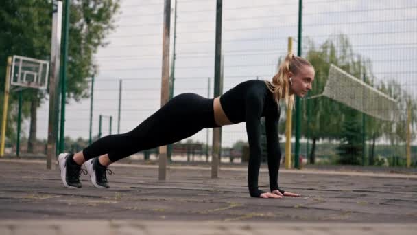 Een Sportplein Staat Een Opgepompt Meisje Plank Luistert Naar Motiverende — Stockvideo