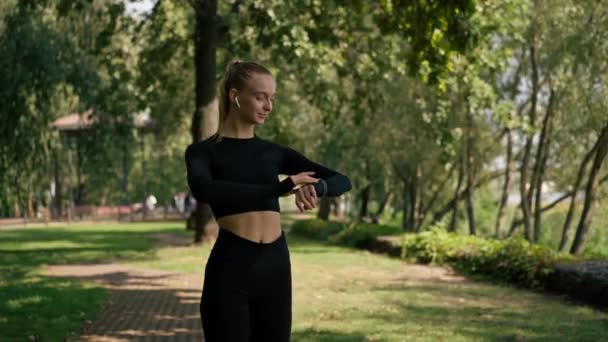Sportliches Mädchen Beim Morgendlichen Joggen Park Blickt Auf Die Sportuhr — Stockvideo
