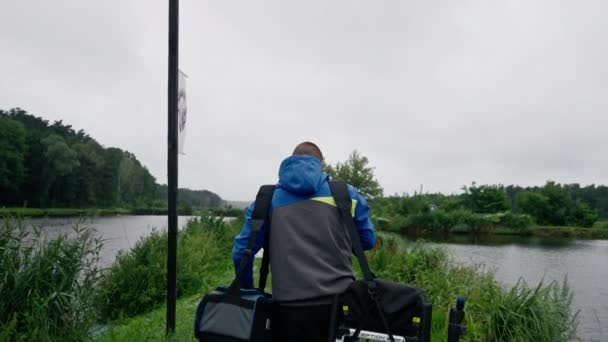 彼の肩にバッグを運ぶプロの機器釣りで賭ける漁師のバックビュー — ストック動画