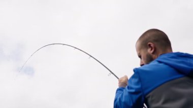 Balıkçı oltayla ya da dönen aletlerle nehir kıyısında dikiz aynasından balık tutar.