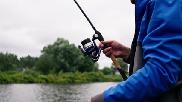 Balıkçı Oltayla Dönen Aletlerle Nehir Kıyısında Dikiz Aynasından Balık Tutar — Stok video
