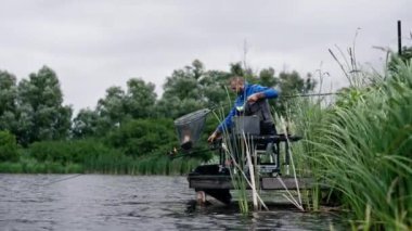 Balıkçı elinde olta ya da profesyonel aletlerle nehrin kıyısında durmuş balık tutarak gölden balık çıkarıyor.