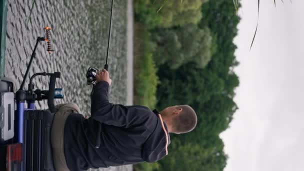 Video Verticale Pescatore Con Canna Pesca Filatura Attrezzi Professionali Seduto — Video Stock