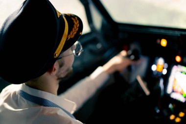 Pilot uçuş sırasında bir uçağın kokpitinde döner direksiyon tutuyordu.
