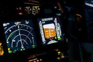 Bir uçak kokpiti merkez panelinin ana uçuş ekran navigasyonuyla yakın plan uçak pilotu panellerini göster
